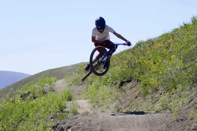 SKI IDAHO THIS SUMMER : A rider performs a whip last summer at the mountain bike park at Soldier Mountain, which the resort opened last summer. Eleven of Idaho's 19 ski areas offer mountain biking in the summer, as well as scenic chairlift and gondola rides, hiking and trail running, disc golf, zipline tours, horseback riding, and more. Visit skiidaho.us for more details. (Photo by Gary Peterson for Ski Idaho)